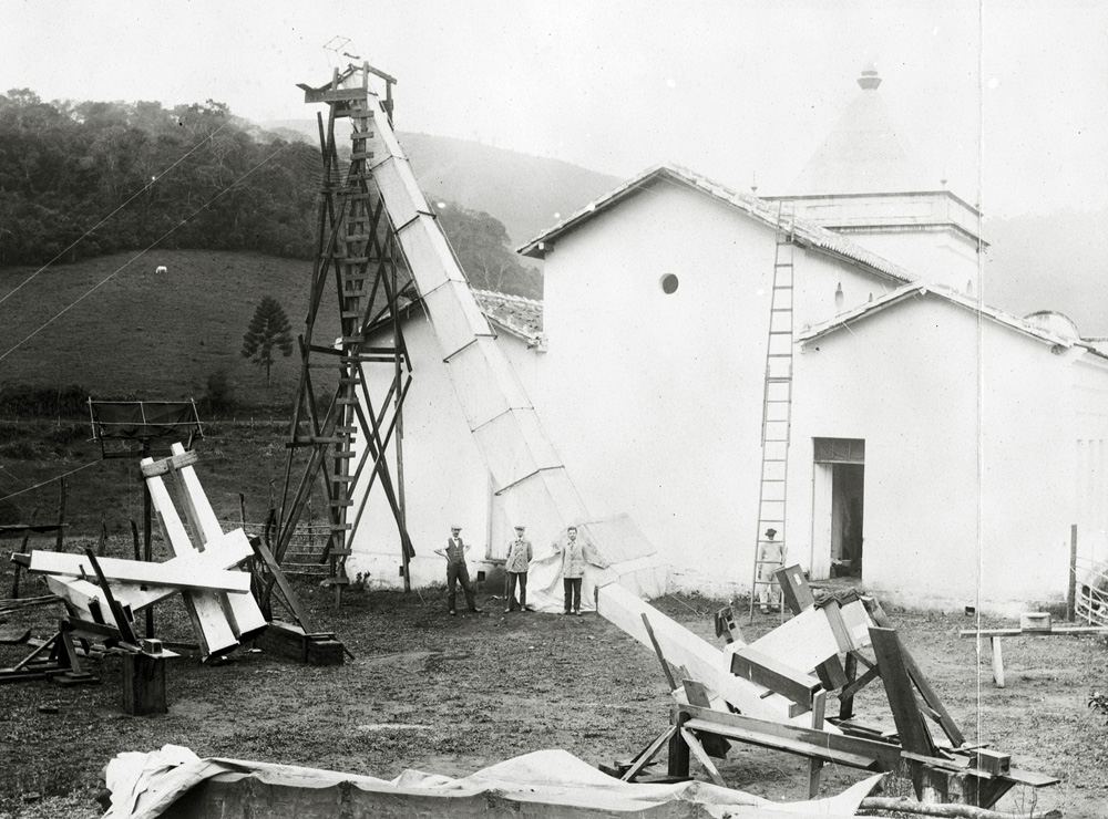 Argentinean eclipse expedition site at Cristina, Brazil, 1912. f Charles D. Perrine, mechanic James O. Mulvey, assistant astronomer,
Enrique Chaudet and a fourth individual are visible. Three of them are stood next to their largest camera with a 12 metre focal length, and there are cameras of 335.3 centimetre focal distance also visible.